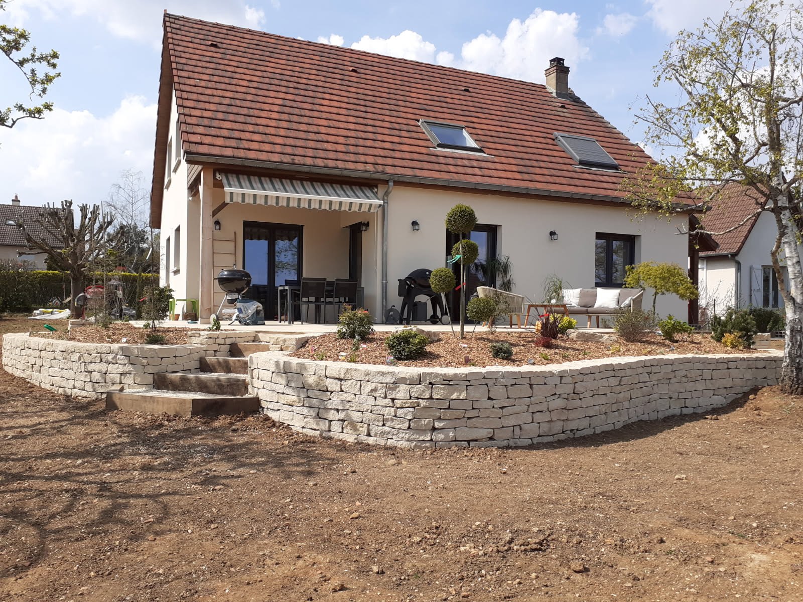 Aménagement paysager complet : terrassement, fondations, murets en pierres jointes, escaliers, terrasse